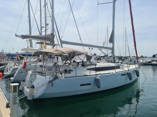 a white boat is docked at a dock at Sleep aboard a modern sailboat in Oeiras in Oeiras