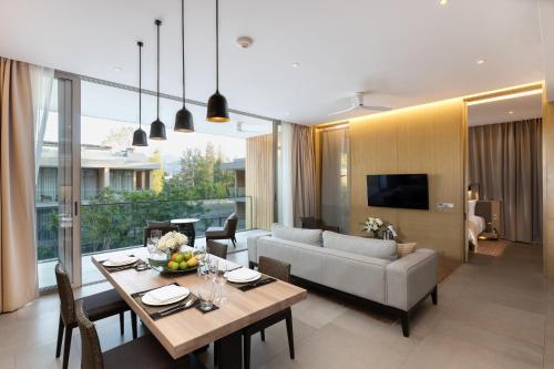 a living room with a table and a couch at Twinpalms MontAzure Phuket Resort in Kamala Beach