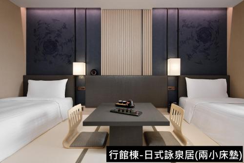 - une chambre avec 2 lits et une table dans l'établissement MU Jiaoxi Hotel, à Jiaoxi