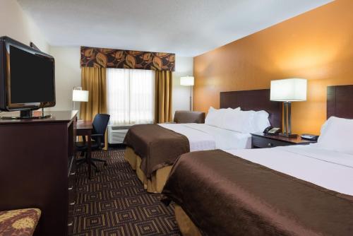 a hotel room with two beds and a flat screen tv at Holiday Inn Knoxville West - Cedar Bluff, an IHG Hotel in Knoxville