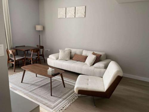 - un salon avec un canapé et une table dans l'établissement 1 BR Luxury Apt by AJ Aljada, à Charjah