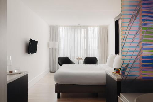 ein Hotelzimmer mit einem Bett und zwei Stühlen in der Unterkunft Designhotel Maastricht in Maastricht