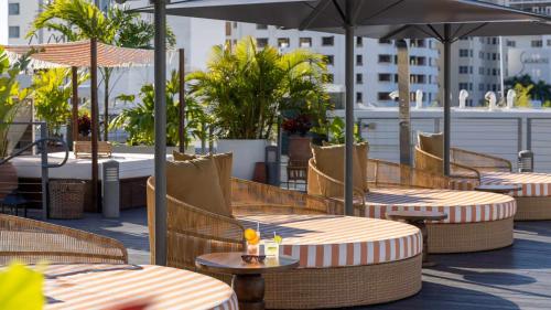 a patio with tables and umbrellas on a rooftop at Uma House by Yurbban South Beach in Miami Beach