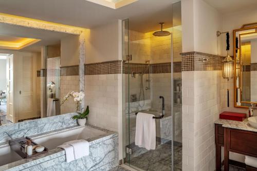 La salle de bains est pourvue d'une baignoire et d'une douche en verre. dans l'établissement Mia Saigon – Luxury Boutique Hotel, à Hô-Chi-Minh-Ville