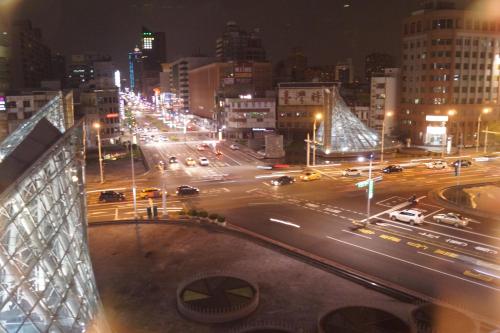 een drukke stadsstraat 's nachts met auto's en verlichting bij Trip GG Hostel in Kaohsiung