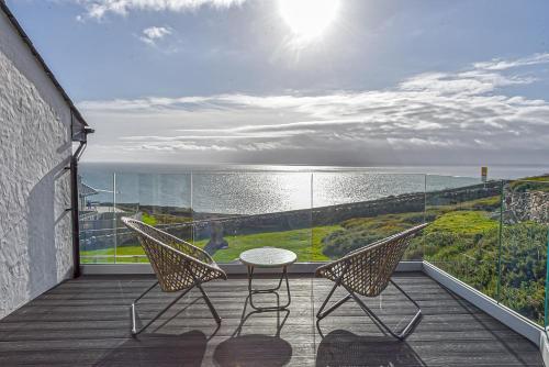 balkon ze stołem i 2 krzesłami oraz oceanem w obiekcie Goferydd, South Stack, Anglesey, 4 bed luxury home, hot tub, dog friendly w mieście Holyhead