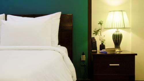 a bedroom with a bed and a lamp on a nightstand at La Serena Boutique Hotel in Ho Chi Minh City