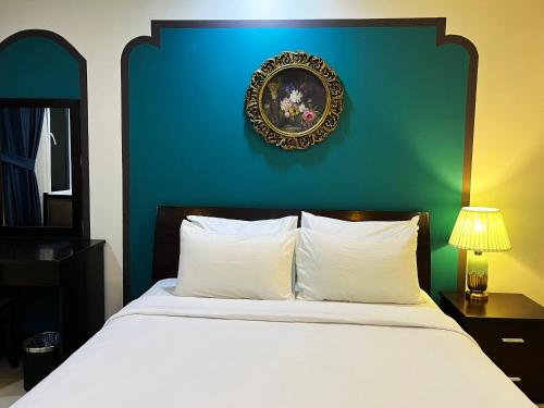 a bedroom with a white bed with a blue wall at La Serena Boutique Hotel in Ho Chi Minh City