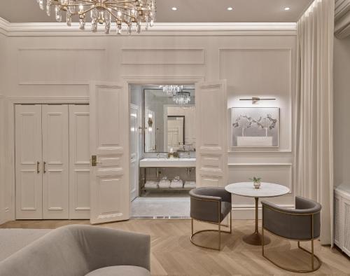 a living room with a table and a chandelier at The Hotel Maria - Preferred Hotels & Resorts in Helsinki