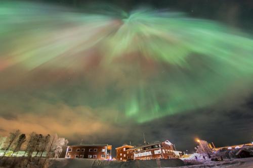 une aurore verte dans le ciel au-dessus d'une ville dans l'établissement Hotel Inari, à Inari