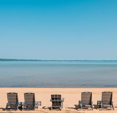 eine Reihe von Liegestühlen am Strand in der Unterkunft Alexandra Inn in Traverse City