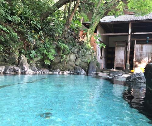 une piscine d'eau bleue devant une maison dans l'établissement Izuya Ryokan - Vacation STAY 22369v, à Yugawara