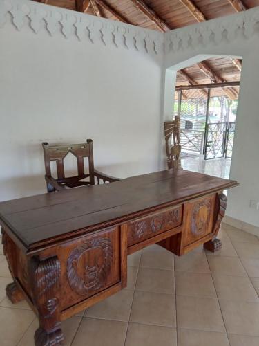 escritorio de madera en una habitación con silla en Mkuu House, en Malindi