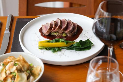 um prato com um pedaço de carne e vegetais sobre uma mesa em Killeen House Hotel em Killarney