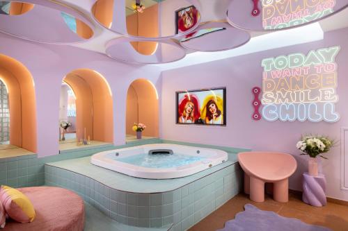 a bathroom with a jacuzzi tub in a pink room at Quinzerie hôtel in Paris