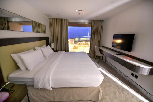 a hotel room with a large bed and a television at Carlton Tower Hotel Kuwait in Kuwait