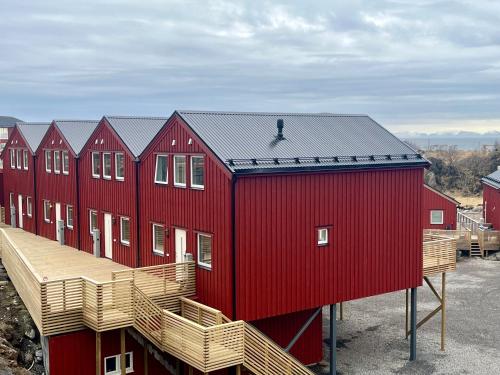 une rangée de maisons rouges avec toit dans l'établissement Finnvika Lodges, à Stamsund