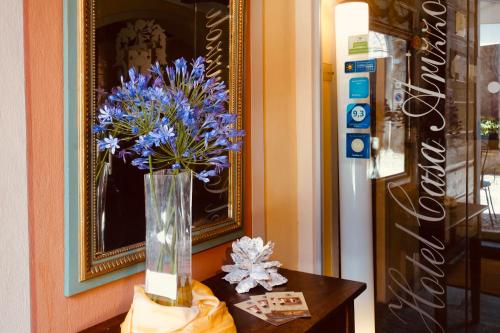 um vaso de flores azuis sentado numa mesa em Hotel Casa Arizzoli em Cannobio