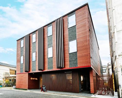 ein großes Backsteingebäude mit Fenstern auf einer Straße in der Unterkunft Guest House Wagokoro in Tokio