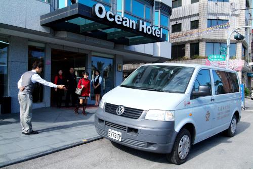 Ocean Hotel Hualien في مدينة هوالين: رجل يقف بجانب سيارة فان بيضاء على شارع