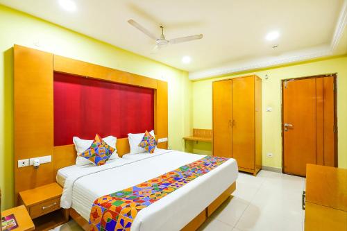 um quarto com uma cama grande e uma cabeceira vermelha em FabHotel Prime Mahalaya Residency - Nr The Rajiv Gandhi Memorial & PVR Grand Galada em Chennai