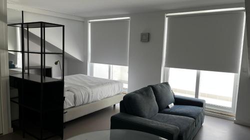 um quarto com uma cama, um sofá e uma cadeira em Oscar Concept Apartments em Lisboa