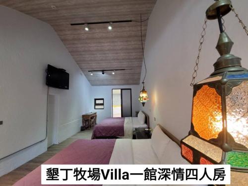 een kamer met een bed en een kroonluchter bij 墾丁牧場Villa Kenting Pasture - Villa B&B in Kenting