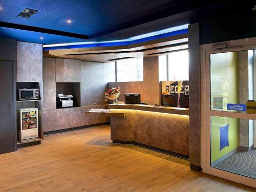 a lobby of a restaurant with a counter and a kitchen at Ibis Budget Strasbourg Centre Gare in Strasbourg