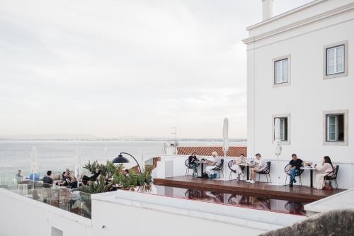 a group of people sitting on the balcony of a building at Memmo Alfama - Design Hotels in Lisbon