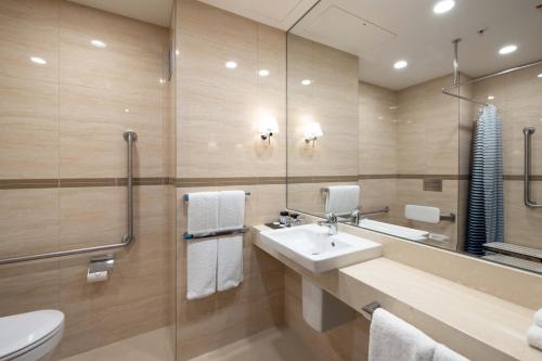 a bathroom with a sink and a mirror at SkyCity Hotel Auckland in Auckland