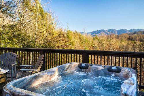 jacuzzi na tarasie z krzesłem w obiekcie Buckhorn Hideaway By Stony Brook Cabins w mieście Gatlinburg