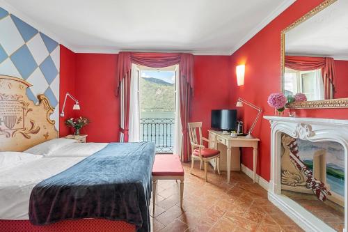 um quarto com paredes vermelhas, uma cama e uma lareira em Hotel Cannobio em Cannobio