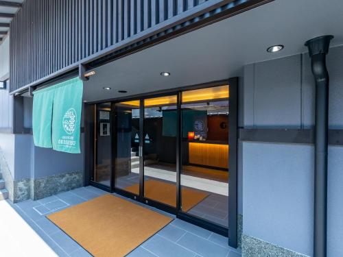 una entrada a un edificio con puertas de cristal en Tabist GROOVE KYOTO OKOSHIYASU, en Kioto