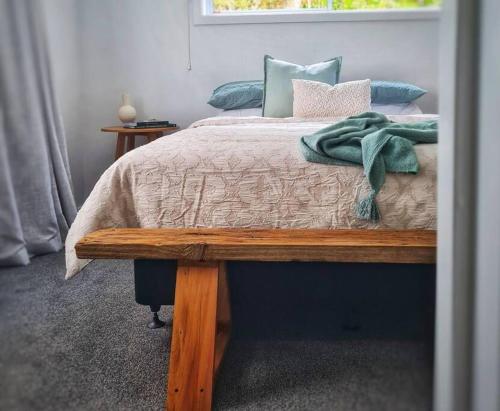 - une chambre avec un lit et un banc en bois dans l'établissement Beachfront escape, à Collingwood