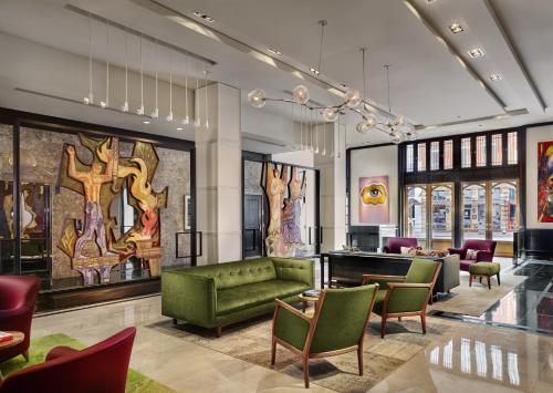 een lobby met een groene bank en stoelen bij The Joule in Dallas