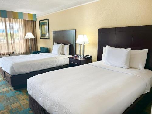 a hotel room with two beds and a chair at Hotel SonoHotel By Monreale IDrive in Orlando