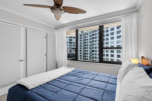 a bedroom with a blue bed and a large window at 2 Bedrooms Unit OceanFront Resort The Alexander in Miami Beach