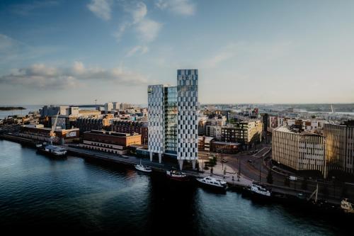 un edificio alto accanto a un fiume con edifici di Clarion Hotel Helsinki a Helsinki