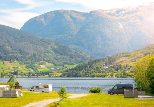 于尔维克Hardanger Guesthouse的两个rvs停泊在有山的湖泊旁