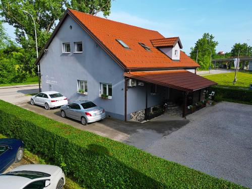 una casa con dos coches estacionados frente a ella en Apartments Cindra, en Karlovac