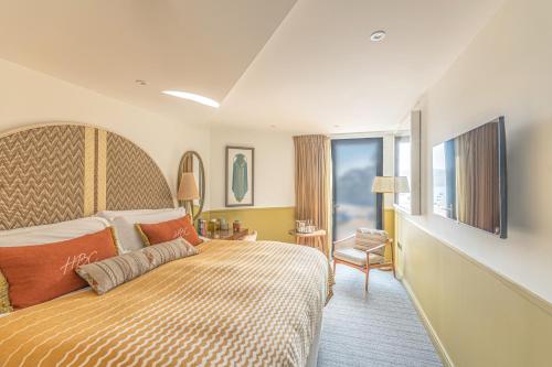 a hotel room with a large bed and a window at Harbour Beach Club, Hotel & Spa in Salcombe