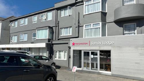 a car parked in front of a large building at Magnuson Hotel Sandy Lodge Newquay in Newquay