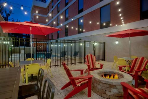 a patio with tables and chairs and a fire pit at Home2 Suites By Hilton Gainesville in Gainesville