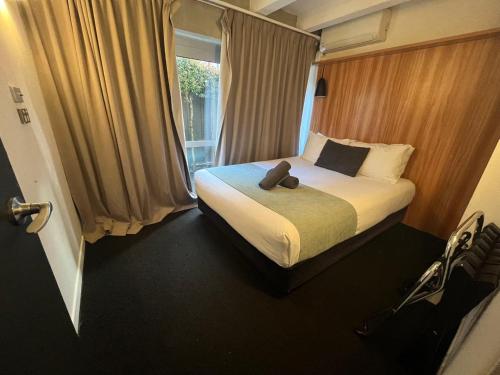 a bedroom with a bed with a teddy bear on it at No. 9 Hotel in Auckland