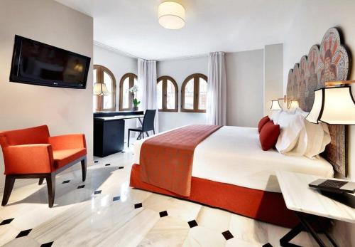 Habitación de hotel con cama, escritorio y TV. en Eurostars Conquistador, en Córdoba