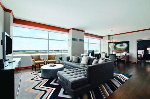 een woonkamer met een bank en een tv bij Grand Hyatt DFW Airport in Irving