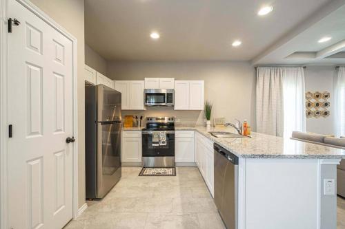 eine Küche mit weißen Schränken und einem Herd mit Backofen in der Unterkunft Gorgeous, Brand New 3 Bedrooms Home- Built 2024, Near SeaWorld & Lackland AFB in San Antonio