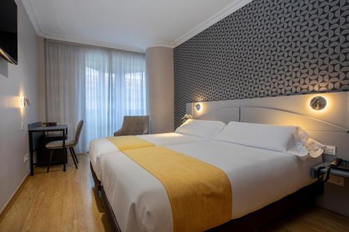 Ліжко або ліжка в номері Hotel Corona de Castilla Burgos