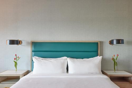 uma cama com almofadas brancas e uma cabeceira verde em Hotel Effie Sandestin Resort, Autograph Collection em Destin