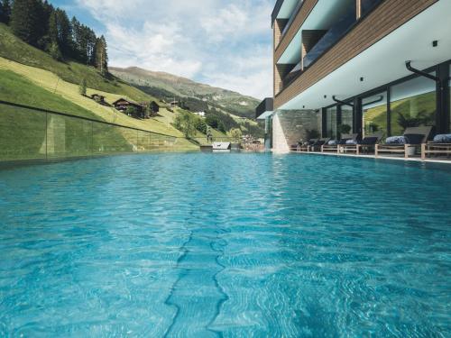 una piscina al centro di una casa di Hotel Tirolerhof 4 Sterne Superior a Tux